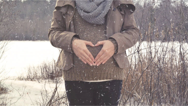 Embarazo en invierno. Mujer embarazada en paisaje invernal